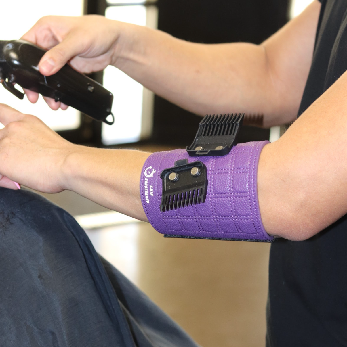 Person using a hair dryer with a purple barber band